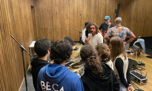 Elementos dos Fogo Fogo em interação com os jovens músicos locais, numa atividade da residência artística.